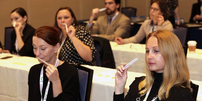 Attendees smelling blotters of cinnamon oil during Richard Pisano Jr.'s presentation.