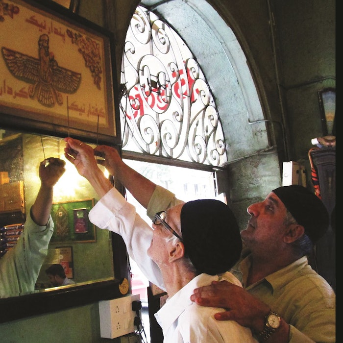 Living legend of India’s Irani Zarthushtis, Aqa Boman Kohinoor, and his son, Afshin, offer incense sticks to the holy Faravar.