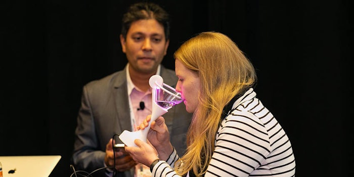 Nimesha Ranasinghe, Ph.D., assistant professor of the School of Computing and Information Science at the University of Maine, showcases his virtual cocktail ('Vocktail') to an attendee during his presentation, 'Augmented and Virtual Flavors.'