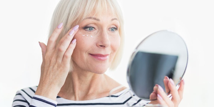 BeautifulMatureWomanUsingEyeCreamLookingInMirror_850x425