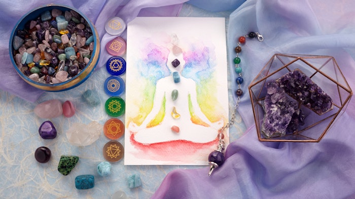 Natural crystals and pendulum on pastel silk background. Reiki background with card.