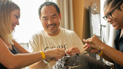 Kien Hoang and assistants add beads to the model's hair for Marrisa Wilson S/S 2023