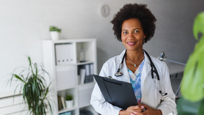 Portrait of female African American doctor standing in her office