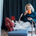 Middle aged woman relaxing with pumpkin shaped cup of hot drink in scandy style hygge interior home with fall mood decor. Lady dreaming, enjoy calm mood without stress, well being alone, self-care concept