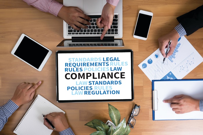 Compliance on a computer screen next to a desk