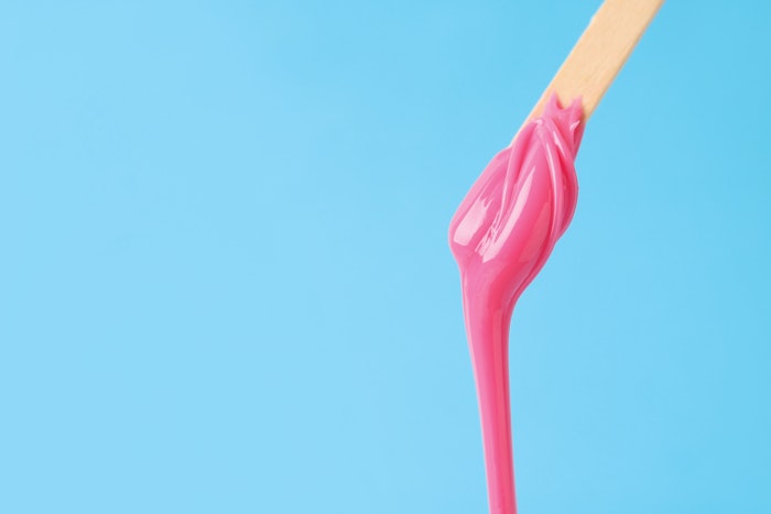 Pink wax dripping off of a stick