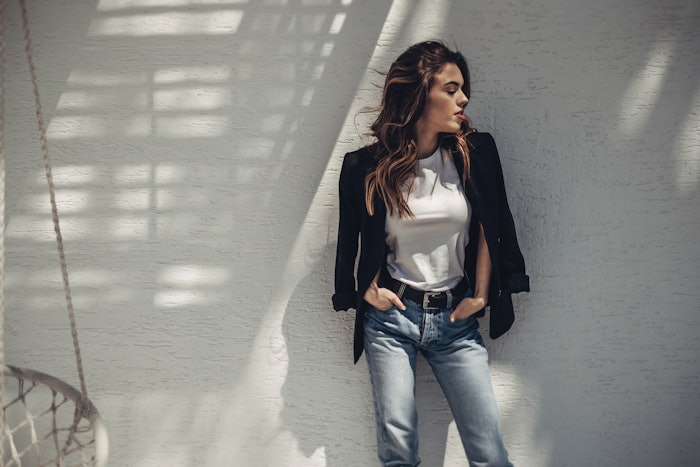 Brunette client leaning against a wall.