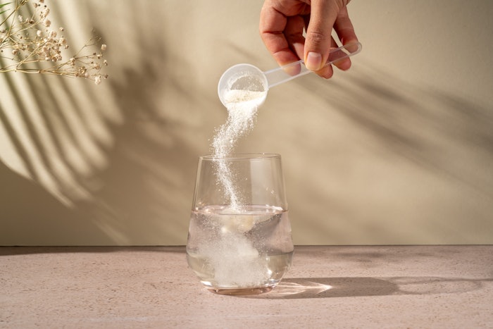 fitness supplement being poured into glass of water