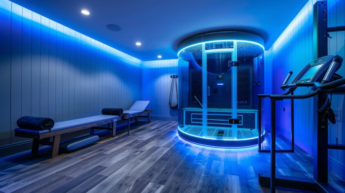 A contemporary fitness room with blue lighting featuring a circular shower and a treadmill.
