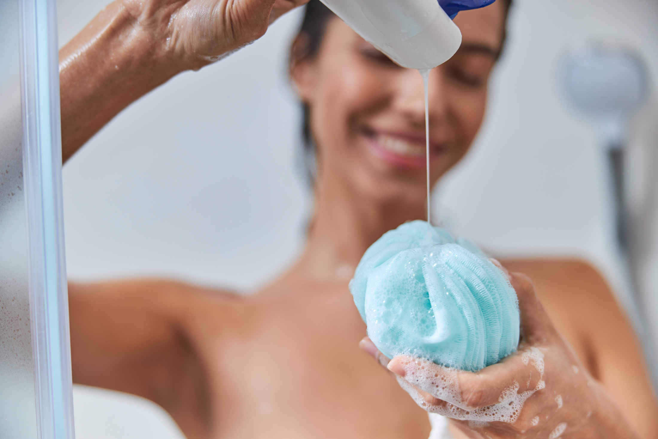 Woman In Shower Pouring Gel On Loofah Adobe Stock 382972380