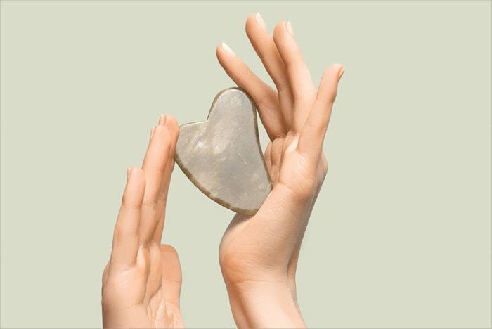 Gua Sha tool in hands for spa treatments