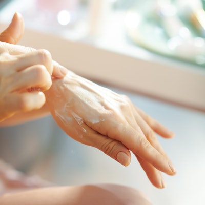 Person applying sunscreen to their hand