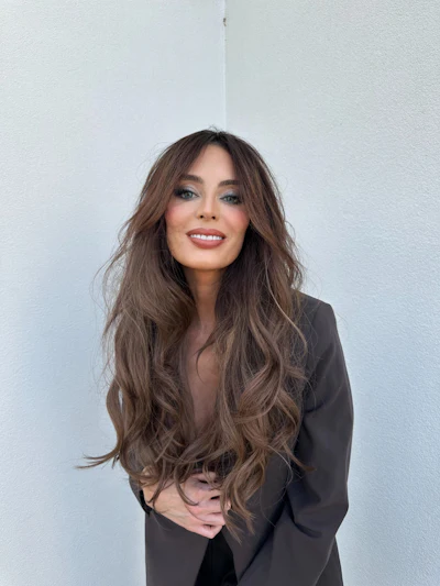 Brunette with long, wavy hair and curtain bangs