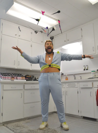 Willy throws hair tools into the air in the back room of his salon.