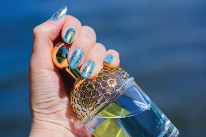 Gold nail stamp art on a blue polish base