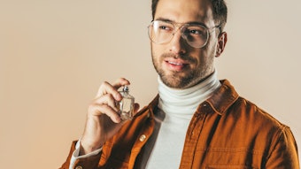 Man Applying Fragrance Brown Jacket Glasses Adobe Stock 184550098