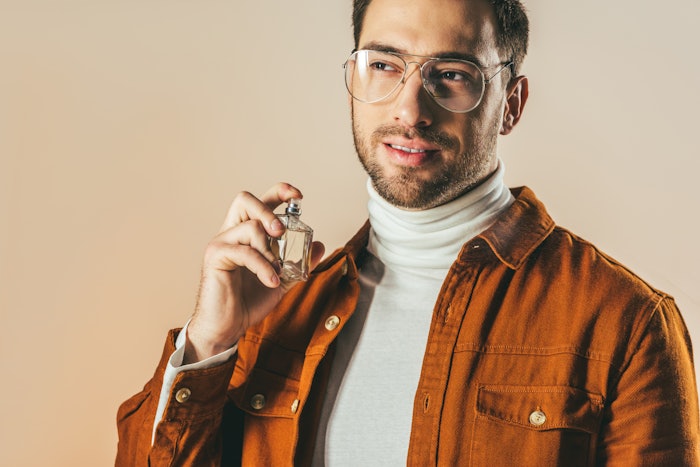 Man Applying Fragrance Brown Jacket Glasses Adobe Stock 184550098