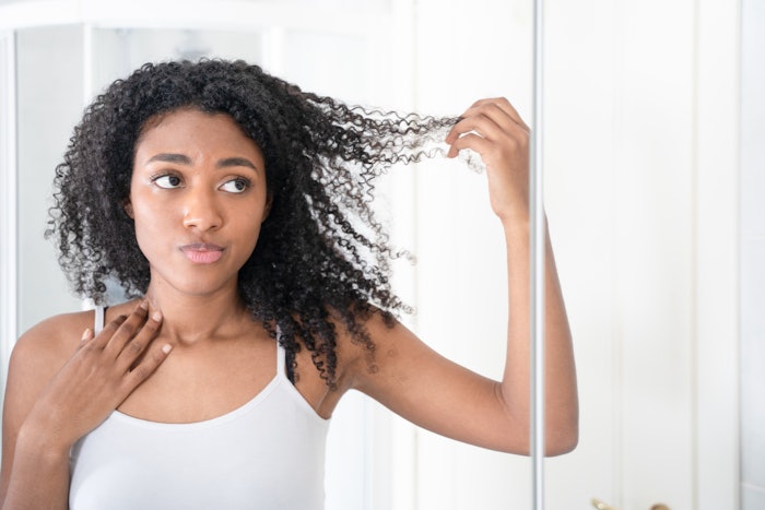 Woman With Black Curly Hair Looking At Split Ends Adobe Stock 1359958663