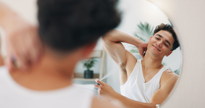 Man With Deodorant In Mirror Adobe Stock 1363485883