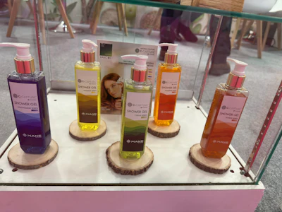 Retail display of colorful shower gel bottles with wooden stands in store window