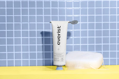 Everist skincare product displayed with roll-on applicator against blue tiled background
