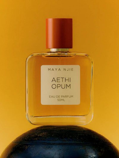 Maya Njie Aethi Opum eau de parfum 50ml bottle with rust-red cap on yellow background