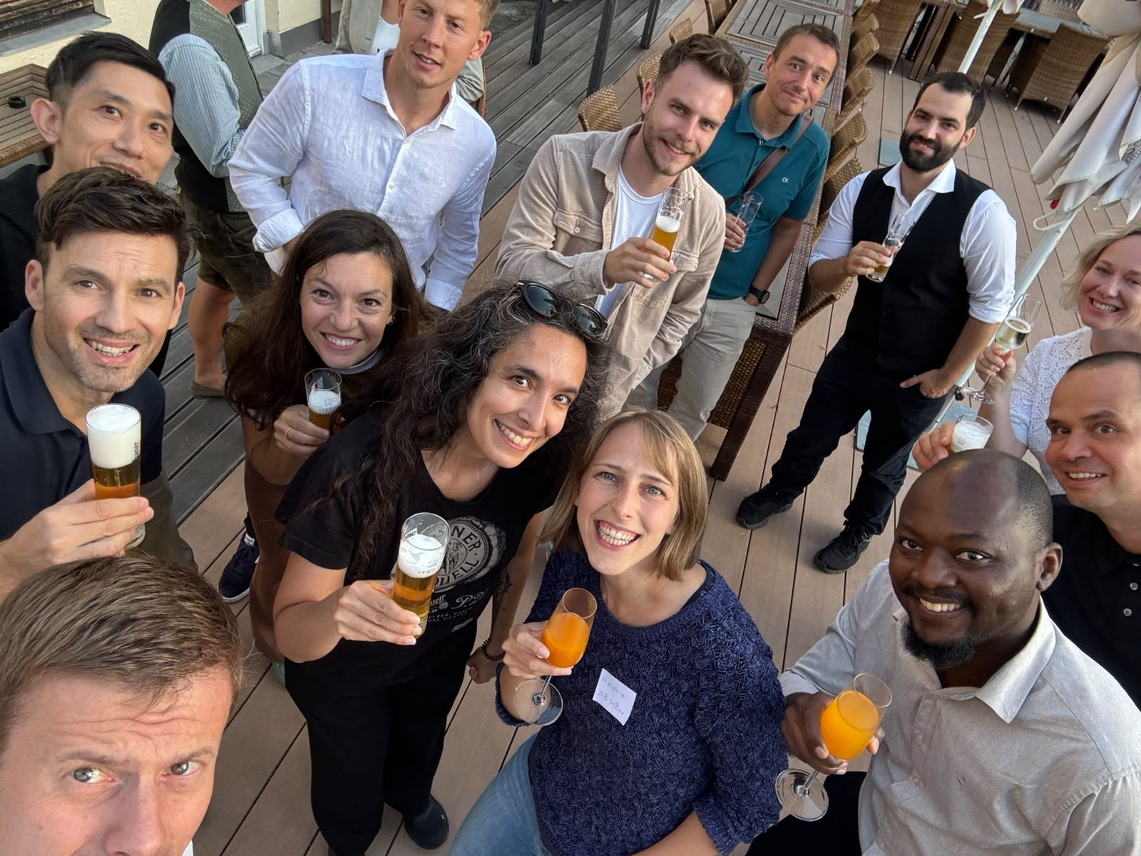Group of diverse professionals smiling and holding drinks at a social gathering or team event