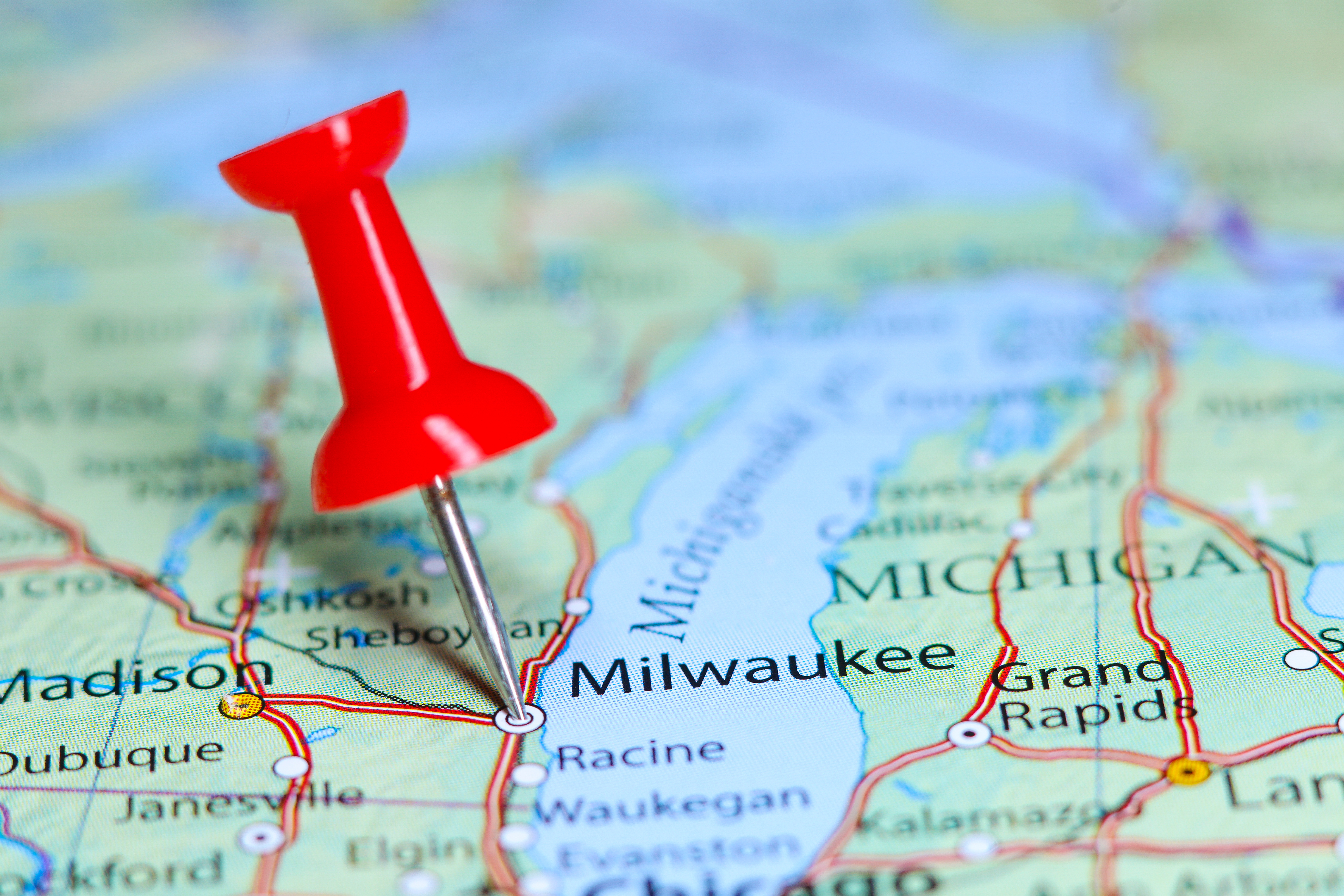 Red pushpin marking Milwaukee on a road map of Wisconsin and surrounding states