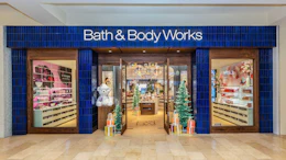 Bath & Body Works retail storefront with blue facade, illuminated signage, and holiday decorations in mall setting